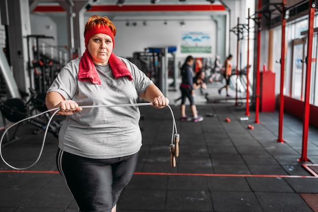 Mujer gorda sudorosa, ejercicio físico con cuerda