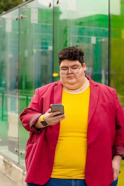 Mujer gordita adulta revisando su teléfono inteligente en la calle