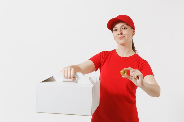 Mujer con gorra roja, camiseta dando caja de pastel de pedido de comida aislada sobre fondo blanco. Mensajero mujer sosteniendo postre en caja de cartón sin marcar, bitcoin, moneda de color dorado. Concepto de servicio de entrega.