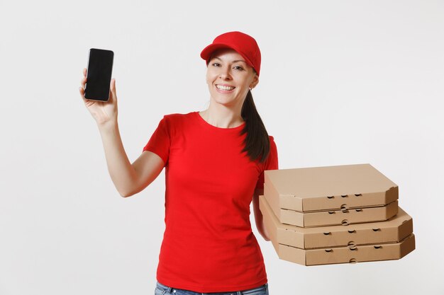 Mujer con gorra roja, camiseta dando orden de comida pizza italiana en cajas de cartón flatbox aisladas sobre fondo blanco. Mensajero femenino que sostiene el teléfono móvil con la pantalla vacía negra en blanco. Concepto de entrega.