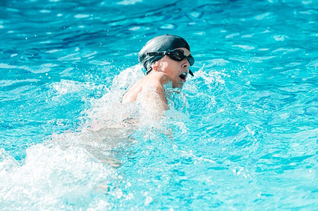 Foto Una mujer en una piscina con gorro de baño – Natación Imagen