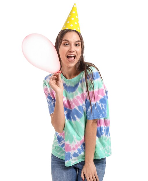 Foto mujer con gorro de fiesta y con globo en blanco. celebración del día de los inocentes