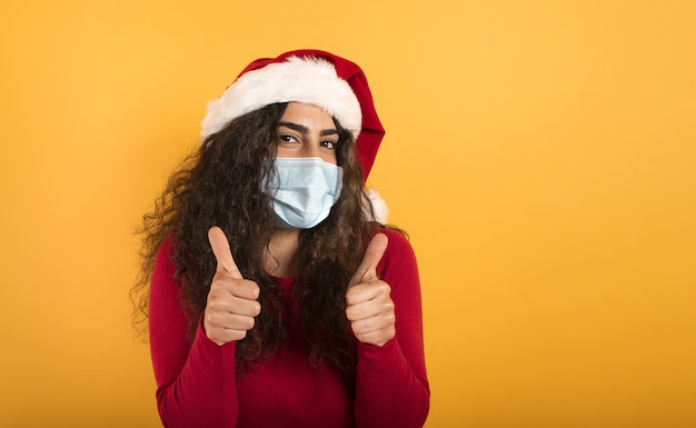 Mujer con gorro navideño se muestra optimista ante la derrota del coronavirus covid 19.