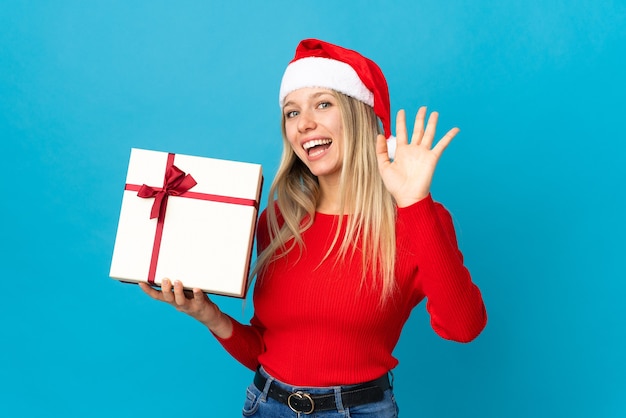 Mujer con gorro de Papá Noel con caja de regalo