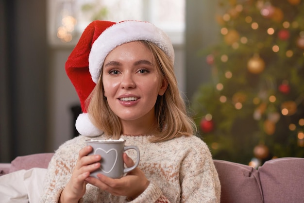 Mujer con gorro de Papá Noel con chocolate caliente