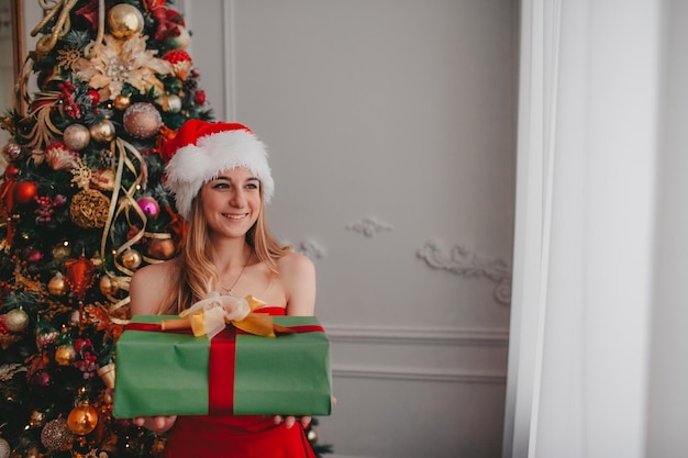 mujer con gorro de Papá Noel con regalos de navidad