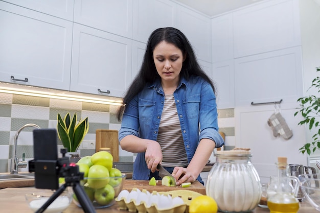 Mujer grabando receta para hacer tarta de manzana