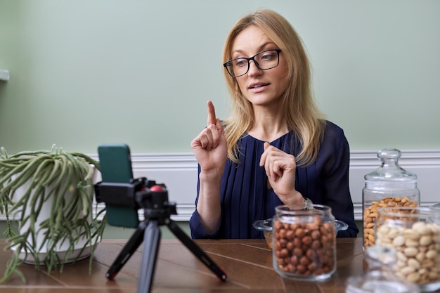 Mujer grabando video sobre nutrición de nueces alimentos saludables