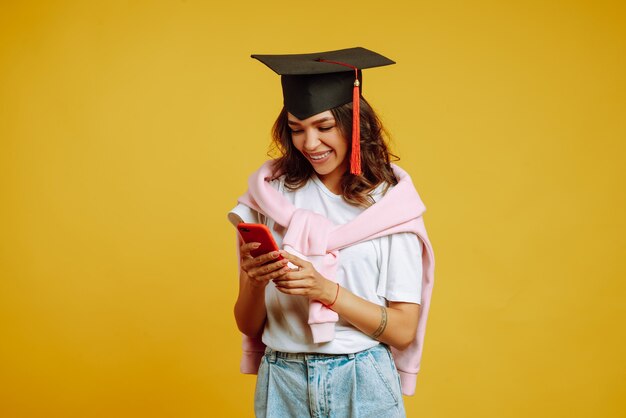 mujer en graduación con smartphone