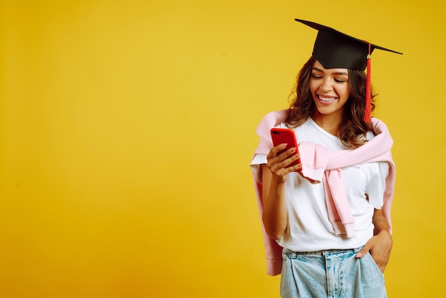 mujer en graduación con smartphone