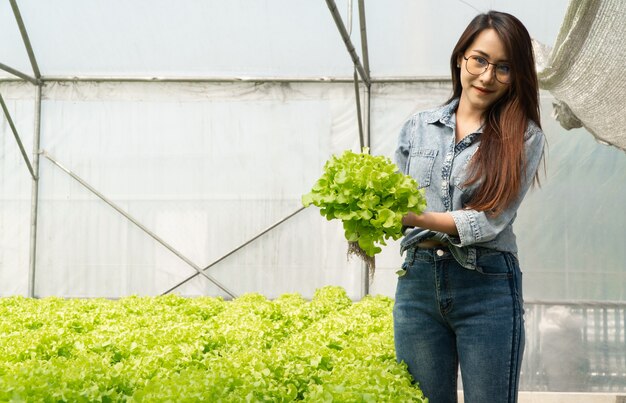 Mujer de granjero asiático con verduras crudas