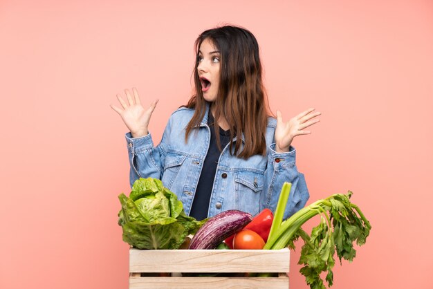 Mujer del granjero con caja de verduras