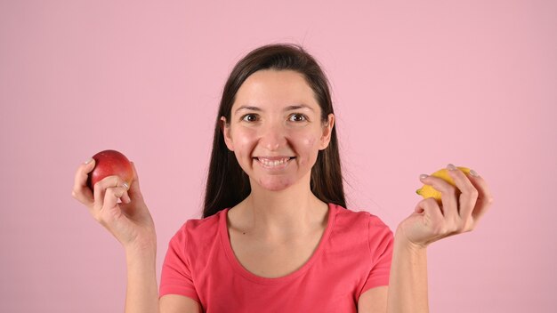 Mujer con granos y frutas en sus manos