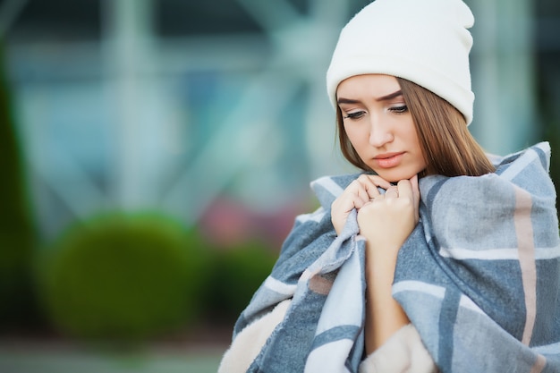 Mujer con gripe al aire libre vestida con gorra