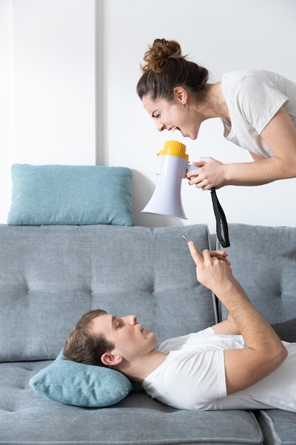 Mujer gritando por megáfono para llamar la atención de su novio