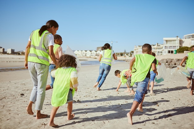 Mujer y grupo de niños limpiando la playa para la comunidad voluntaria y la caridad con el cambio climático y la educación del día de la tierra Amigos maestros voluntarios y recicladores de plástico para el aprendizaje de la contaminación