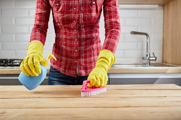 Mujer con guantes de goma en la cocina de limpieza