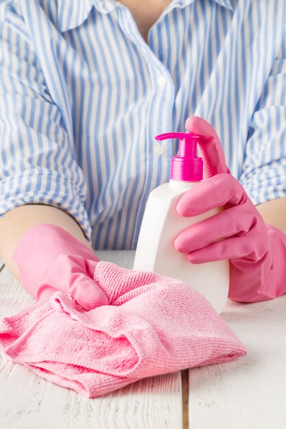 Mujer con guantes y productos de limpieza. Concepto de limpieza del hogar.