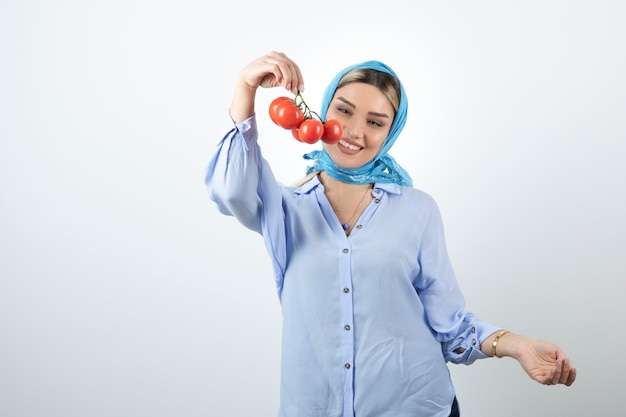 Mujer guapa en mantón azul con tomates rojos frescos