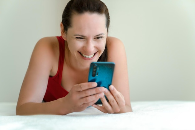 Mujer habla por teléfono con una cámara de video con una sonrisa en la cara