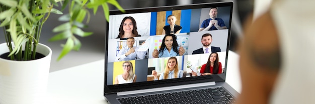 Mujer hablando con colegas internacionales utilizando el servicio de video chat en línea en el lugar de trabajo