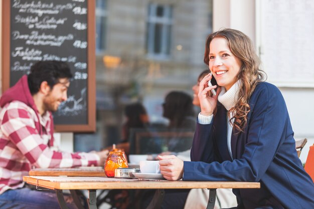 Mujer hablando por teléfono en un café