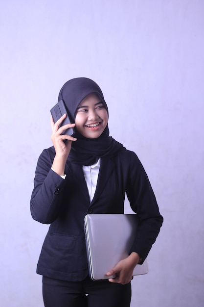 Una mujer hablando por teléfono celular y usando un hiyab.