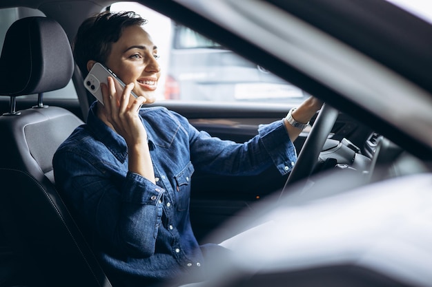 Mujer hablando por teléfono y conduciendo un coche