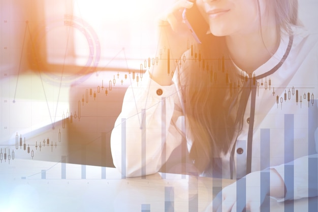 Mujer hablando por teléfono y gráficos financieros