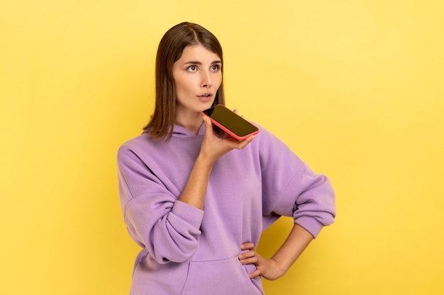 Mujer hablando con un teléfono inteligente usando la aplicación de voz digital grabando un mensaje buscando información