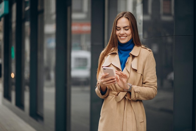 Mujer hablando por teléfono junto al banco