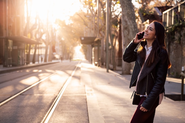 Foto mujer hablando por teléfono mientras cruza la calle