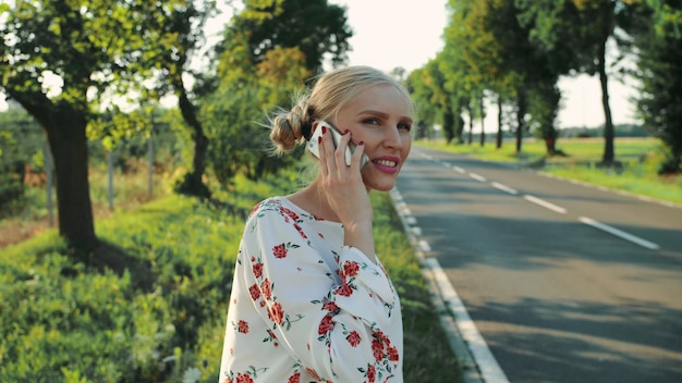 Mujer hablando por teléfono mientras hacía autostop