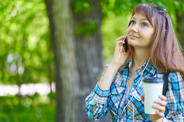 Mujer hablando por teléfono en el parque de verano