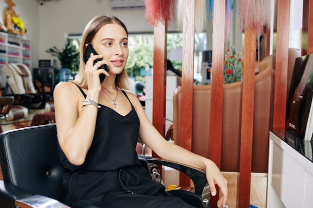 Mujer hablando por teléfono en la peluquería