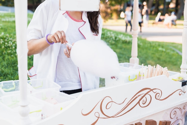 Mujer hace algodón dulce en el verano en el parque.