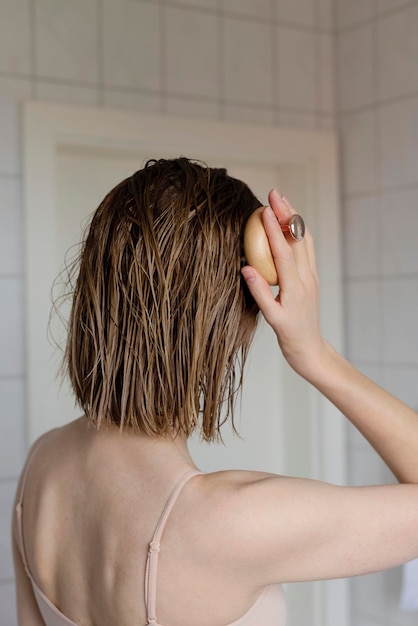 Mujer hace un auto masaje en la cabeza para el crecimiento del cabello