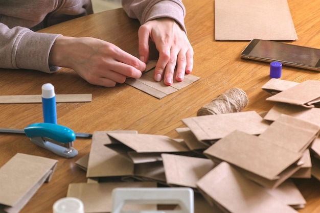 Una mujer hace una bolsa para el calendario de Adviento de Navidad de papel kraft