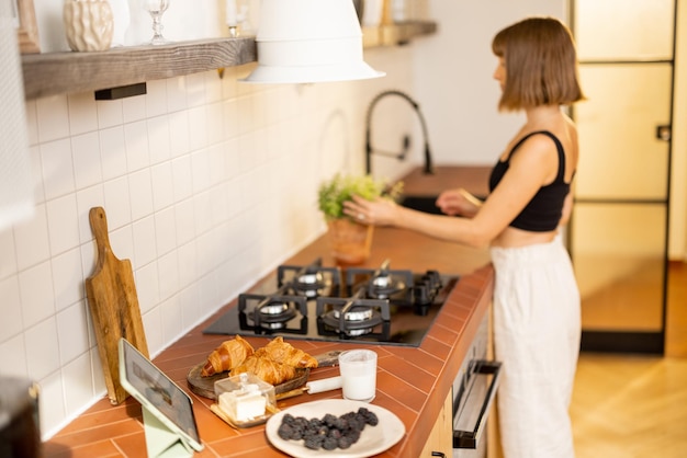 Mujer hace un desayuno en la cocina en casa