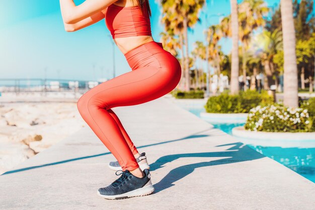 La mujer hace ejercicios de estiramiento en el gimnasio al aire libre en un día soleado