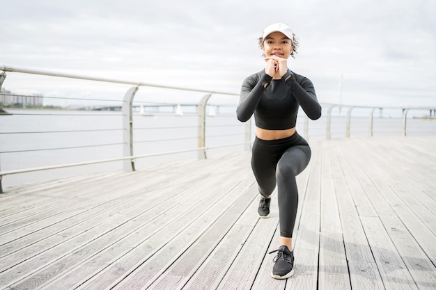 Una mujer hace ejercicios de fitness usa un rastreador en la mano un reloj inteligente para entrenamiento deportivo en ropa deportiva