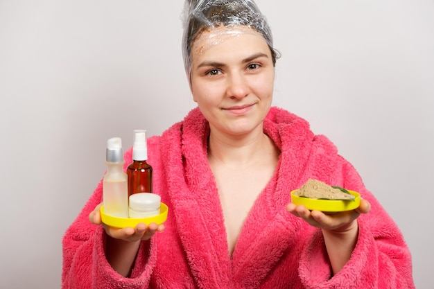 Una mujer hace una mascarilla para el cabello.