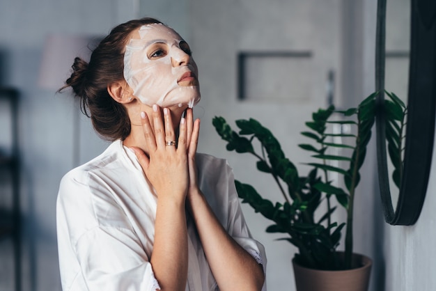 La mujer hace tratamientos de rejuvenecimiento facial en casa.