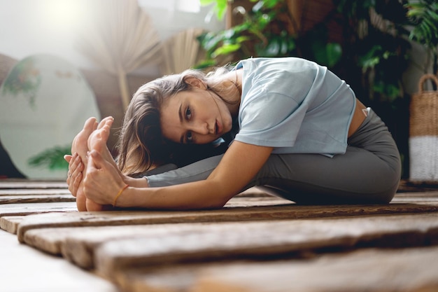 Una mujer hace yoga Aeróbicos para el desarrollo Flexibilidad y movilidad de las articulaciones Entrenador físico