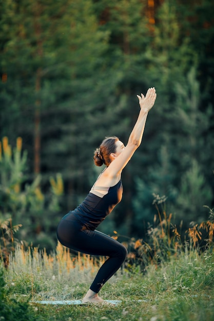 Una mujer hace yoga al aire libre El concepto de deporte