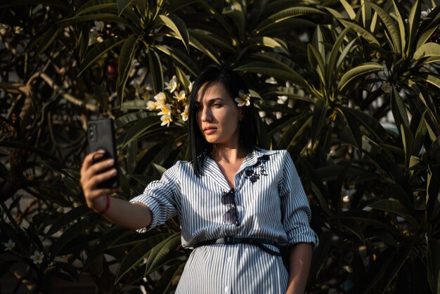 Mujer hacer selfie en jardín con flores