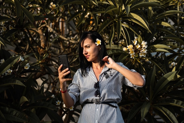 Mujer hacer selfie en jardín con flores