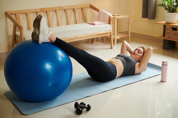 Mujer haciendo abdominales en casa