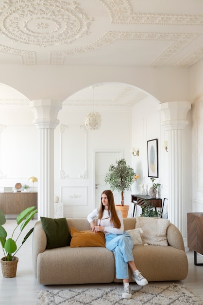 Foto mujer haciendo actividades diarias en una habitación mínimamente decorada.