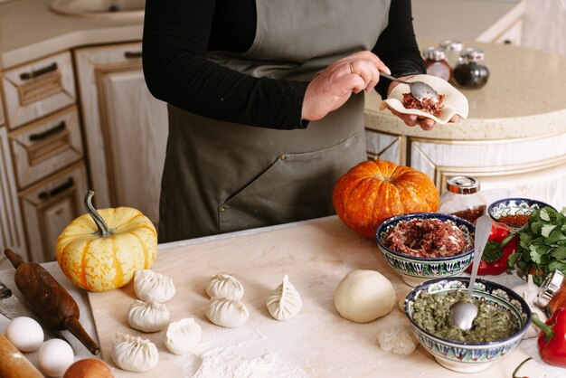 Mujer haciendo albóndigas con carne picada